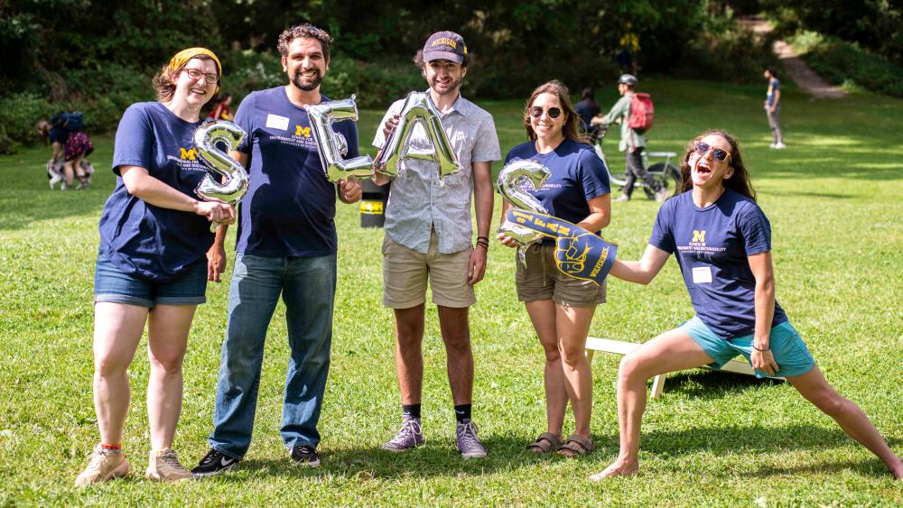 Students holding silver balloon letters to spell SEAS