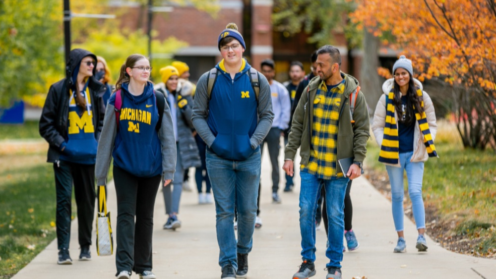 A group of students walking on campus in UM-Dearborn gear