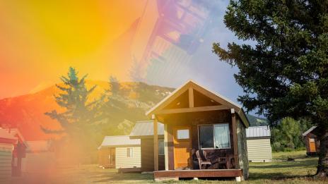 Wood cabins of Camp Davis in front of mountains covered in green trees