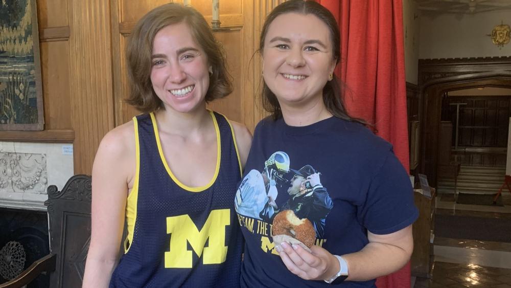 Two students at the Martha Cook Building holding donuts 