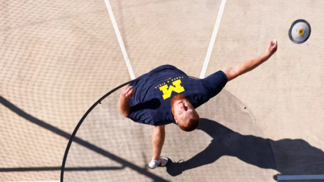 U-M Men's track and field player throwing during shot put event