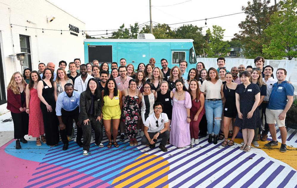 Picture of Erb students, the backdrop is a bright outdoor seating area at a local restaurant.