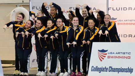 U-M Artistic Swim team celebrate at Collegiate Championship Other image: Swimmers' legs pointing out of the water