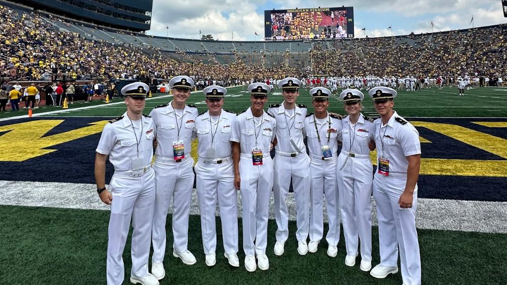 Midshipmen in dress whites following flag raising in the Big House