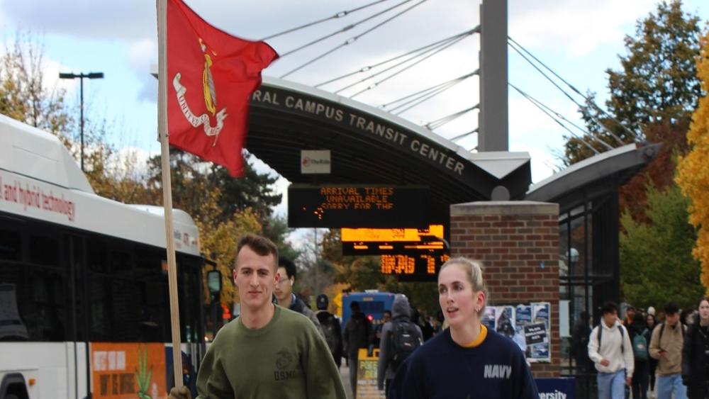 Midshipmen running with the Marine flag during Alex's Great Race