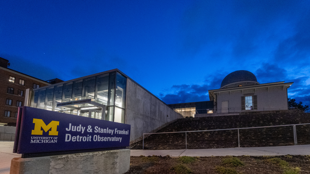 Blue sign in front of the observatory dome taken in early evening.